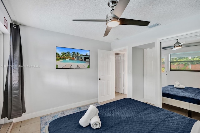 7531 Simms St, Hollywood, FL 33024 - bedroom featuring light tile patterned flooring, a textured ceiling, ceiling fan, and baseboards