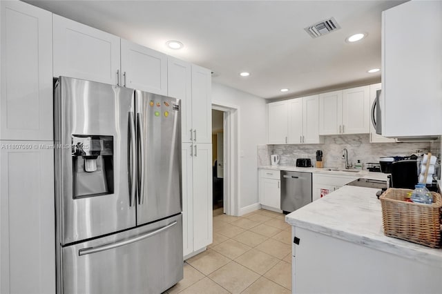 7531 Simms St, Hollywood, FL 33024 - kitchen featuring appliances with stainless steel finishes, a sink, white cabinetry, light tile patterned floors, and recessed lighting