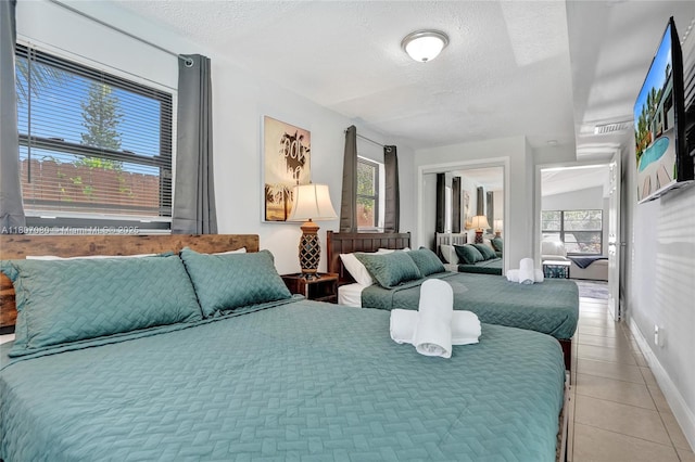 7531 Simms St, Hollywood, FL 33024 - bedroom with multiple windows, a textured ceiling, light tile patterned floors, and baseboards
