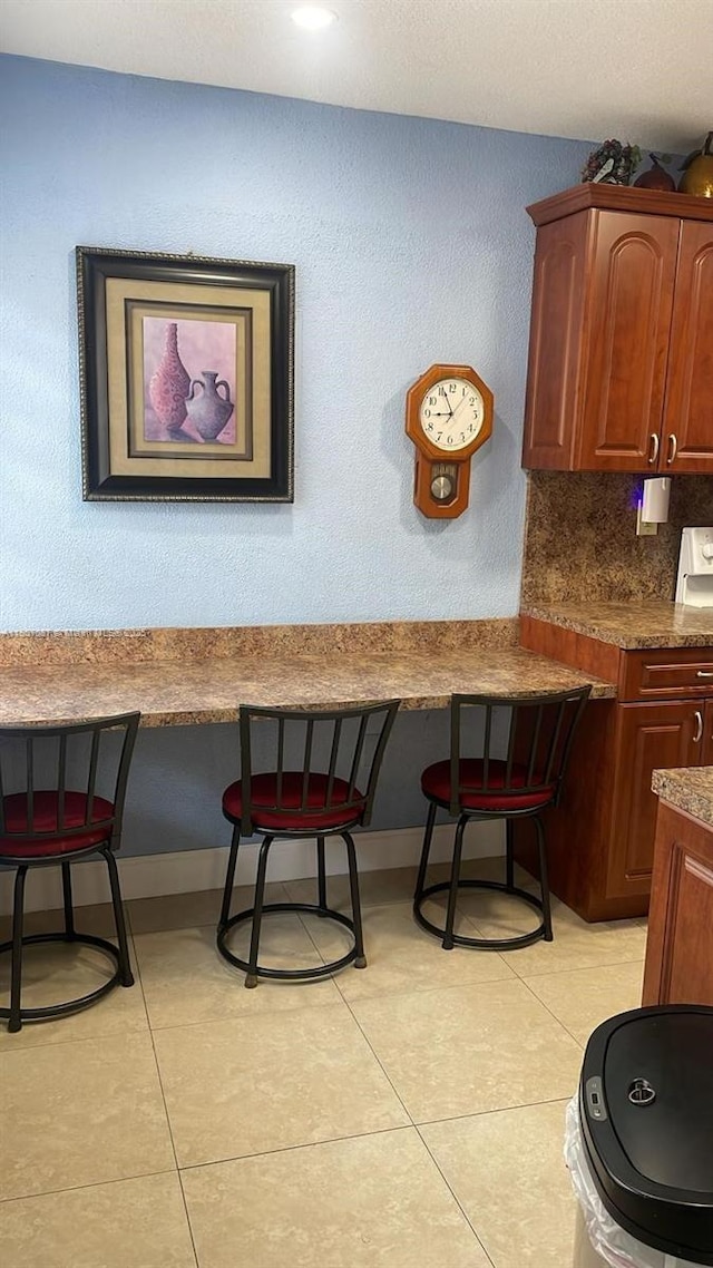 1560 W 46th St Unit 229, Hialeah, FL 33012 - dining room with light tile patterned floors, a textured wall, and baseboards
