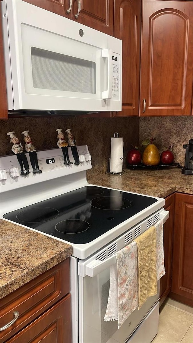 1560 W 46th St Unit 229, Hialeah, FL 33012 - kitchen featuring white appliances, decorative backsplash, light tile patterned floors, and brown cabinetry