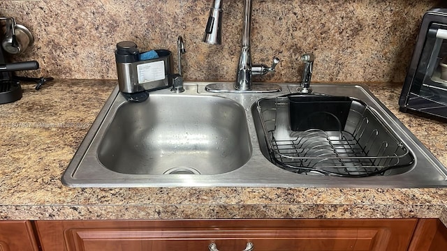 1560 W 46th St Unit 229, Hialeah, FL 33012 - kitchen view of a sink, brown cabinetry, tile countertops, and backsplash