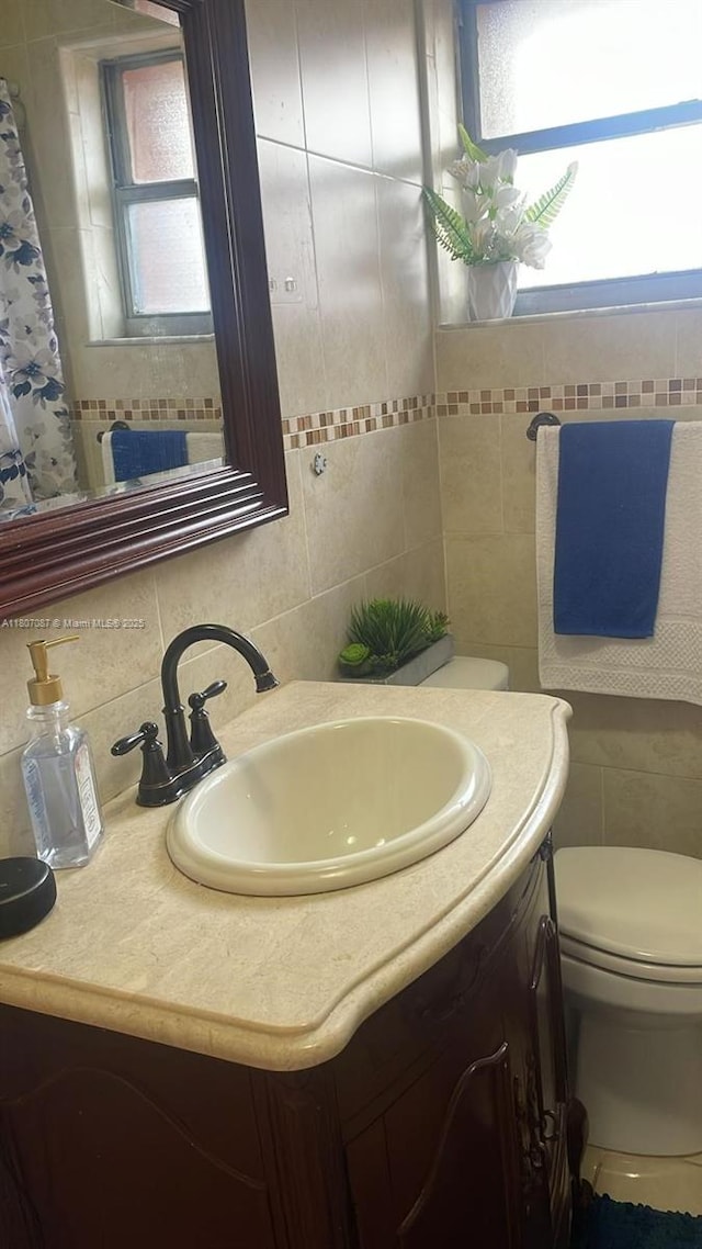 1560 W 46th St Unit 229, Hialeah, FL 33012 - bathroom featuring tile walls, vanity, toilet, and tasteful backsplash