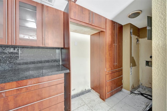 9033 SW 123rd Ct Unit 101, Miami, FL 33186 - kitchen featuring glass insert cabinets, decorative backsplash, dark countertops, and brown cabinetry