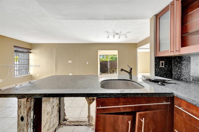 9033 SW 123rd Ct Unit 101, Miami, FL 33186 - kitchen with a sink, a textured ceiling, a peninsula, tile patterned flooring, and dark stone countertops