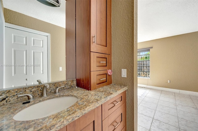 9033 SW 123rd Ct Unit 101, Miami, FL 33186 - bathroom featuring a textured wall, vanity, baseboards, and tile patterned floors