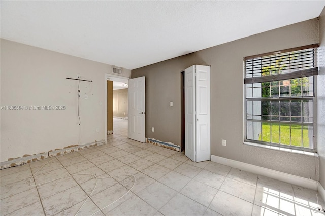 9033 SW 123rd Ct Unit 101, Miami, FL 33186 - empty room with healthy amount of natural light, baseboards, and light tile patterned floors
