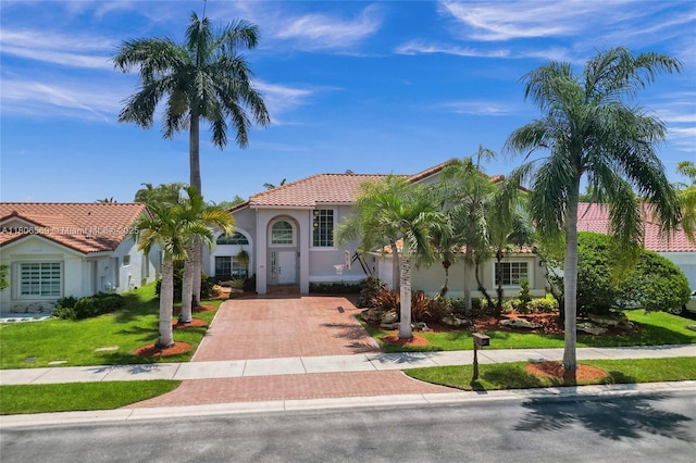 594 Spinnaker, Weston, FL 33326 - mediterranean / spanish-style home with decorative driveway, stucco siding, a tiled roof, and a front yard