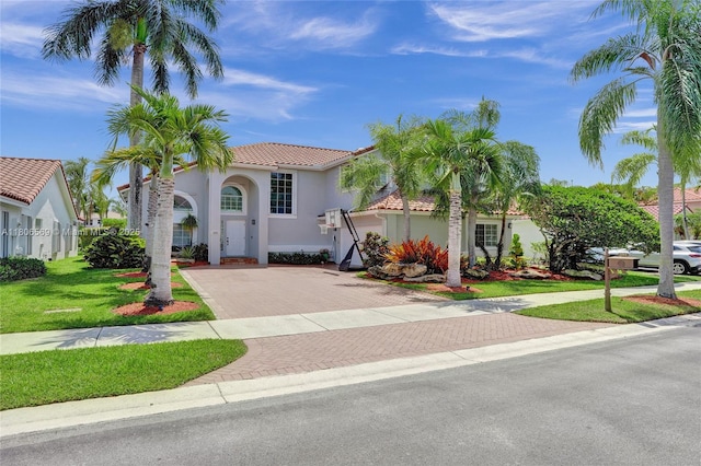 594 Spinnaker, Weston, FL 33326 - mediterranean / spanish home with a tiled roof, decorative driveway, stucco siding, and a front lawn