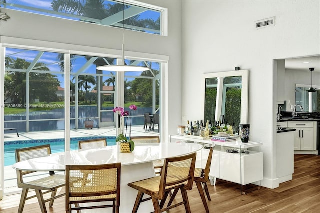 594 Spinnaker, Weston, FL 33326 - dining area with wood finished floors, a high ceiling, healthy amount of natural light, baseboards, and a water view
