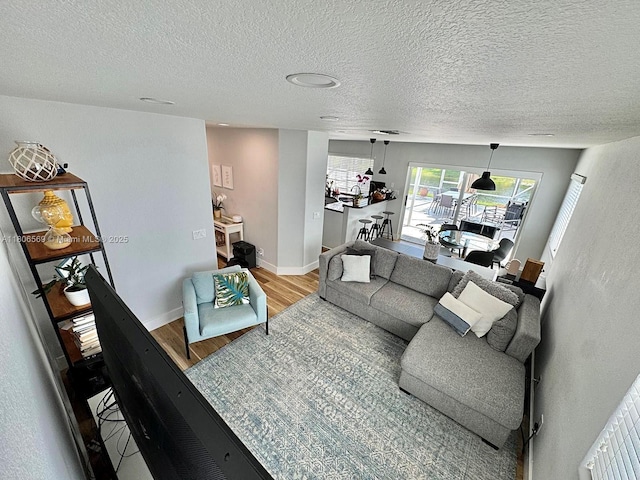 594 Spinnaker, Weston, FL 33326 - living room with wood finished floors, a textured ceiling, and baseboards