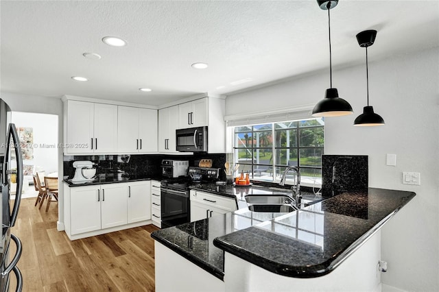 594 Spinnaker, Weston, FL 33326 - kitchen featuring black appliances, a sink, decorative backsplash, a peninsula, and light wood-type flooring