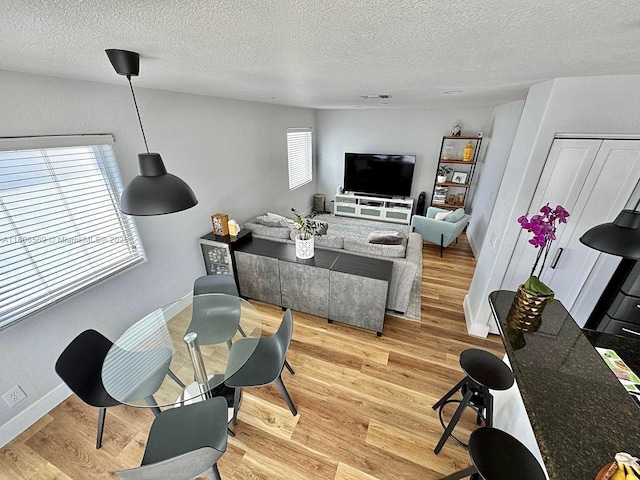 594 Spinnaker, Weston, FL 33326 - living room featuring a textured ceiling, light wood-style floors, and baseboards