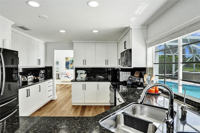 594 Spinnaker, Weston, FL 33326 - kitchen with freestanding refrigerator, a sink, tasteful backsplash, recessed lighting, and white cabinetry