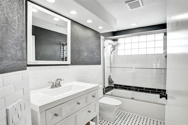 594 Spinnaker, Weston, FL 33326 - bathroom with recessed lighting, combined bath / shower with glass door, toilet, vanity, and tile walls