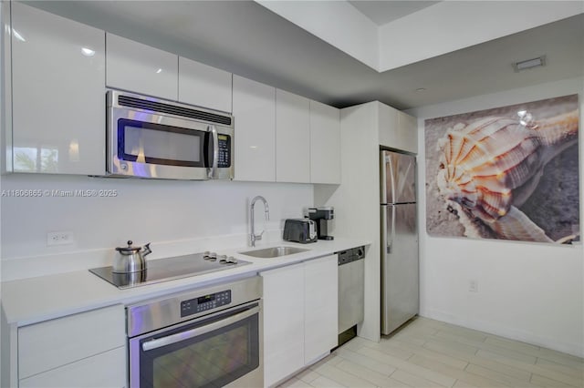 2602 E Hallandale Beach Blvd Unit R407, Hallandale Beach, FL 33009 - kitchen with stainless steel appliances, a sink, white cabinets, and modern cabinets