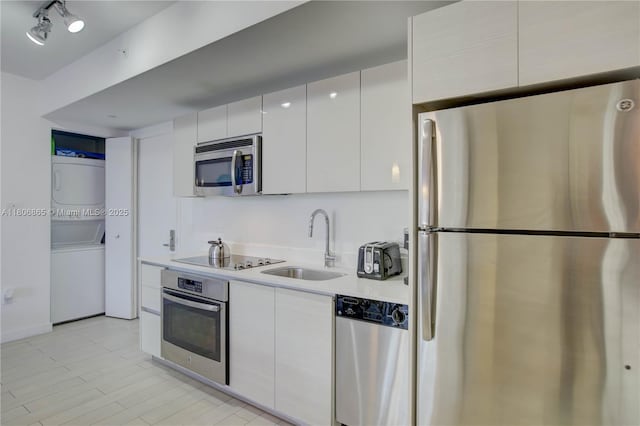 2602 E Hallandale Beach Blvd Unit R407, Hallandale Beach, FL 33009 - kitchen with appliances with stainless steel finishes, stacked washer / drying machine, a sink, light countertops, and modern cabinets