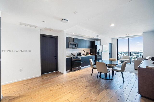 398 NE 5th St Unit 4518, Miami, FL 33132 - dining area with light wood-type flooring and a wall of windows