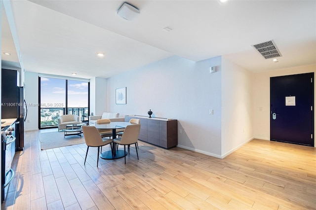 398 NE 5th St Unit 4518, Miami, FL 33132 - dining area featuring floor to ceiling windows, light wood-style floors, and baseboards