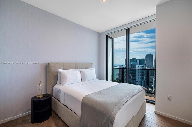 398 NE 5th St Unit 4518, Miami, FL 33132 - bedroom with a wall of windows, wood finished floors, baseboards, and a view of city