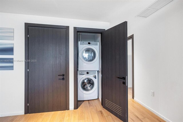 398 NE 5th St Unit 4518, Miami, FL 33132 - washroom featuring stacked washer / dryer, light wood-style floors, and baseboards