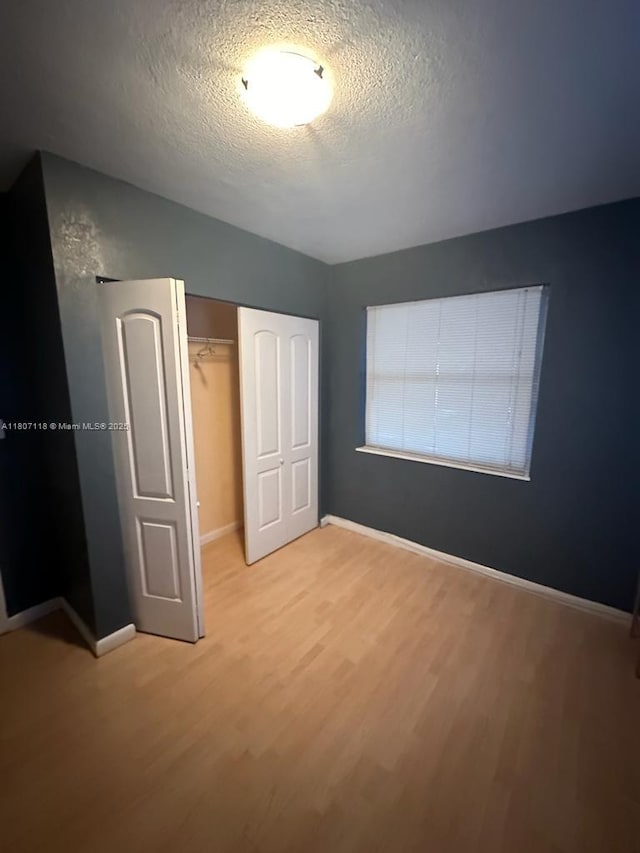 131 Carolina Ave, Fort Lauderdale, FL 33312 - unfurnished bedroom featuring light wood-type flooring, a textured ceiling, baseboards, and a closet