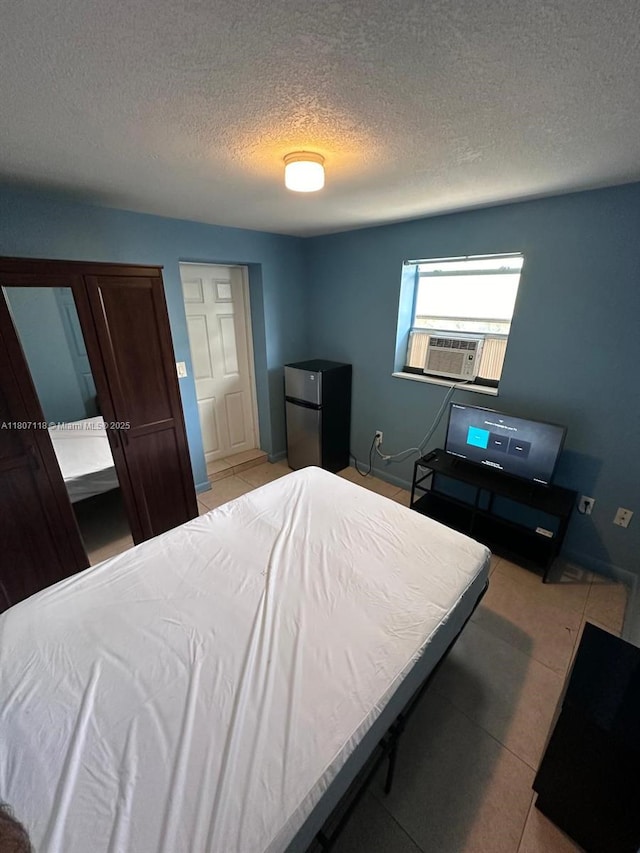 131 Carolina Ave, Fort Lauderdale, FL 33312 - bedroom featuring freestanding refrigerator, cooling unit, a textured ceiling, and light tile patterned floors