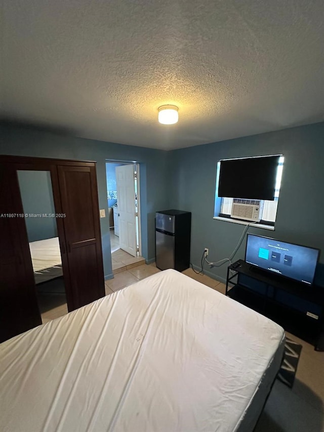 131 Carolina Ave, Fort Lauderdale, FL 33312 - bedroom featuring freestanding refrigerator, a textured ceiling, cooling unit, and light tile patterned flooring