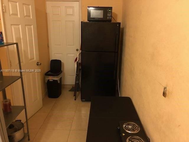 131 Carolina Ave, Fort Lauderdale, FL 33312 - kitchen with black appliances, light tile patterned floors, and dark countertops
