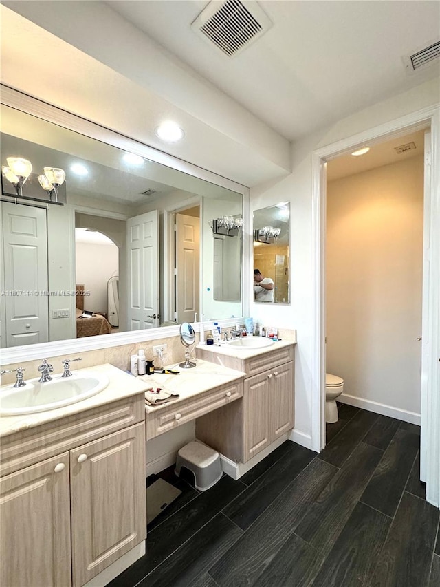 826 E Spinnaker Dr E, Hollywood, FL 33019 - ensuite bathroom featuring double vanity, wood finish floors, toilet, baseboards, and recessed lighting