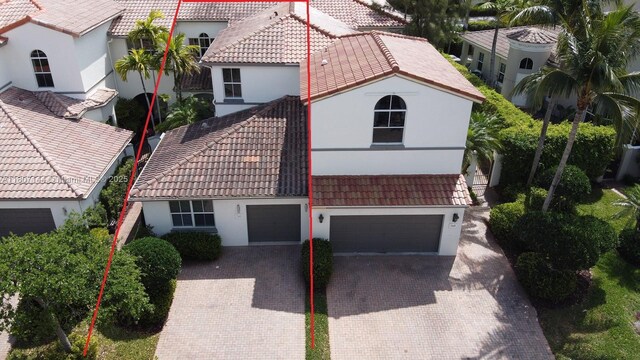 826 E Spinnaker Dr E, Hollywood, FL 33019 - view of front facade featuring a tiled roof, decorative driveway, stucco siding, and an attached garage