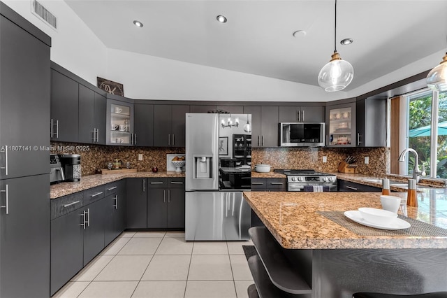 10020 SW 145th Pl, Miami, FL 33186 - kitchen with stainless steel appliances, vaulted ceiling, glass insert cabinets, pendant lighting, and backsplash