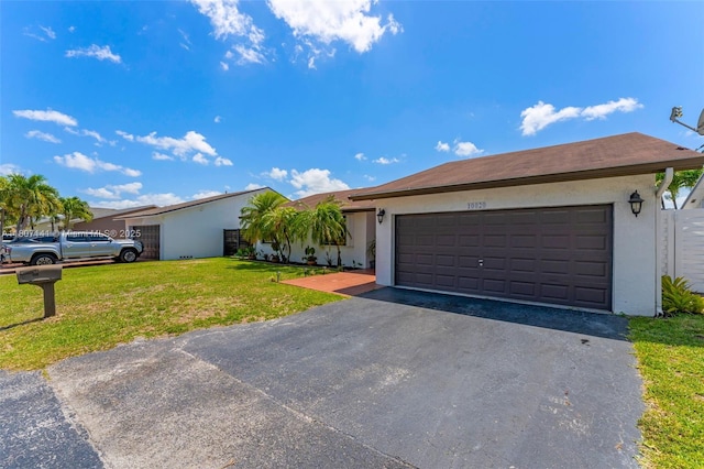 10020 SW 145th Pl, Miami, FL 33186 - single story home featuring asphalt driveway, a garage, a front lawn, and stucco siding