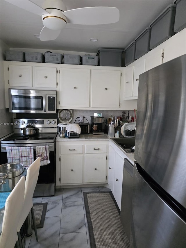 1425 Atlantic Shores Blvd Unit 204, Hallandale Beach, FL 33009 - kitchen with appliances with stainless steel finishes, light marble finish flooring, light countertops, and white cabinetry