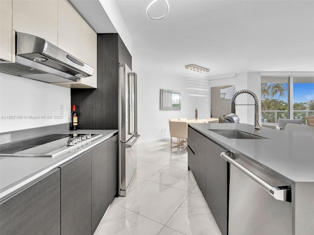 9821 E Bay Harbor Dr Unit 302, Bay Harbor Islands, FL 33154 - kitchen with appliances with stainless steel finishes, a sink, extractor fan, light marble finish flooring, and light countertops