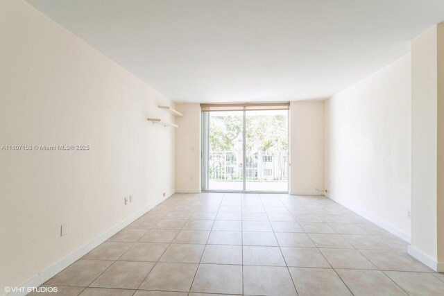 750 NE 64th St Unit B308, Miami, FL 33138 - spare room with floor to ceiling windows, light tile patterned floors, and baseboards
