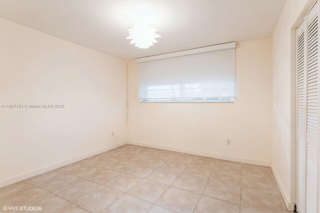 750 NE 64th St Unit B308, Miami, FL 33138 - unfurnished bedroom with a closet, light tile patterned floors, and baseboards