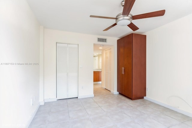 750 NE 64th St Unit B308, Miami, FL 33138 - unfurnished bedroom featuring baseboards, ceiling fan, a closet, and light tile patterned floors