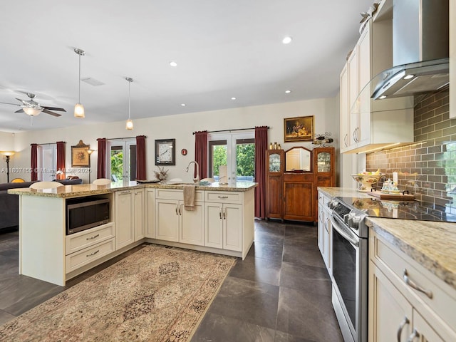 15150 SW 240th St, Homestead, FL 33032 - kitchen with appliances with stainless steel finishes, wall chimney range hood, cream cabinetry, open floor plan, and backsplash