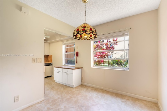 446 Flanders J 4460, Delray Beach, FL 33484 - unfurnished dining area with light tile patterned floors, baseboards, and a textured ceiling