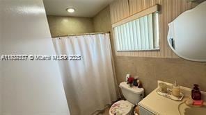 2200 N Park Ln Unit 311, Hollywood, FL 33021 - bathroom with vanity, curtained shower, and toilet