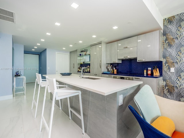 650 Ne 32 3302, Miami, FL 33137 - kitchen with a sink, modern cabinets, light marble finish flooring, a center island with sink, and a breakfast bar area