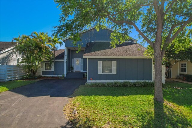 14823 SW 139th Ct, Miami, FL 33186 - view of front of home with board and batten siding, asphalt driveway, a front yard, and a shingled roof