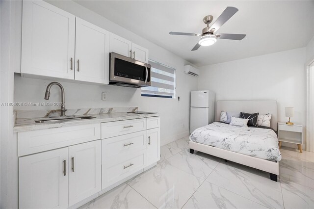 9240 SW 57th Ter, Miami, FL 33173 - bedroom with freestanding refrigerator, a sink, a wall unit AC, light marble finish flooring, and baseboards