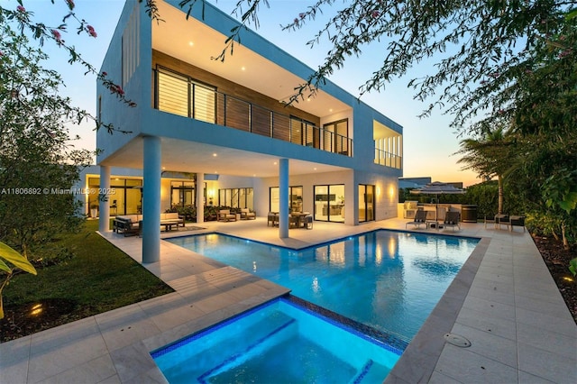 16703 S Botaniko Dr S, Weston, FL 33326 - back of property at dusk featuring a balcony, outdoor lounge area, a patio area, and stucco siding
