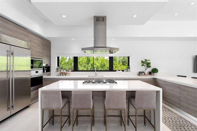 16703 S Botaniko Dr S, Weston, FL 33326 - kitchen with stainless steel appliances, modern cabinets, island exhaust hood, a breakfast bar area, and recessed lighting