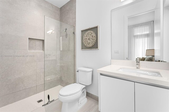 16703 S Botaniko Dr S, Weston, FL 33326 - ensuite bathroom featuring a walk in shower, toilet, vanity, baseboards, and wood finished floors