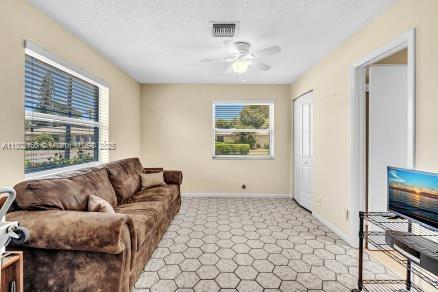 13785 Flora Pl Unit A, Delray Beach, FL 33484 - living area with light colored carpet and a ceiling fan