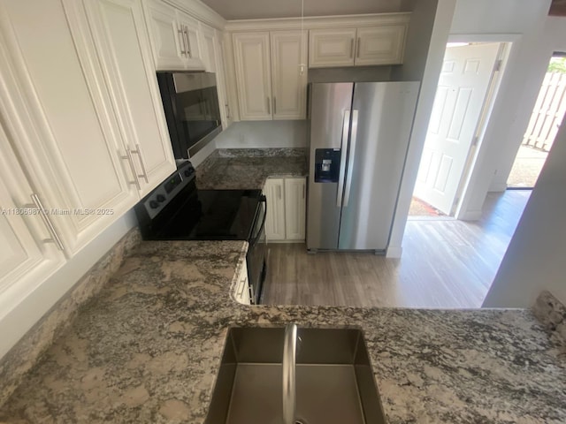 8015 SW 21st Ct, Davie, FL 33324 - kitchen featuring stainless steel appliances, light wood finished floors, light stone countertops, and white cabinets