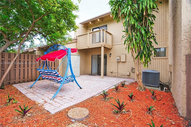8015 SW 21st Ct, Davie, FL 33324 - back of house featuring a balcony, a fenced backyard, a patio, and central AC